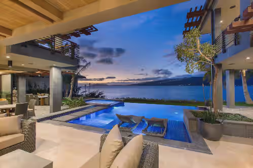 Outdoor lounge with fire and pool views—perfect for evening conversations under the stars. at 10% Off Summer Special! Luxury