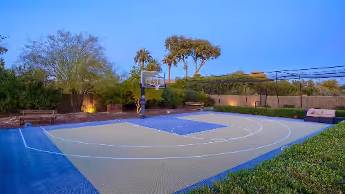 Half court basketball next to the batting cage w/ spectator seating & greenery at Scottsdale's Only Lazy River Retreat-Where