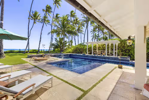 Enjoy palm trees swaying as you recline on the chaise lounges at Kahala Beachside Estate: Luxury Estate w/Pool, Jacuzzi, AC