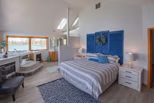 Master bedroom with Jacuzzi tub overlooking lake. at Lake front 4-bedroom vacation home with pool and tiki bar