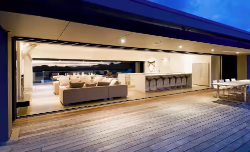 Spacious rear outdoor area with open fire overlooking Oke Bay. at The Oke Beach House